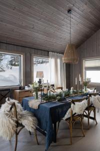 a dining room with a blue table and chairs and windows at Luxurious Mountain Lodge in Ljørdal