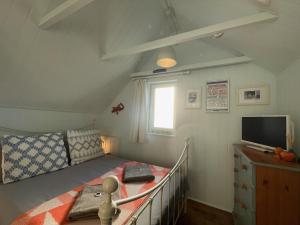 um pequeno quarto com uma cama e uma televisão em Sandown 4 bedroom house St Teath em Saint Teath