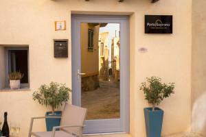 una puerta a un edificio con 2 sillas y una mesa en PORTA SOPRANA luxury guest House & spa, en Sclafani