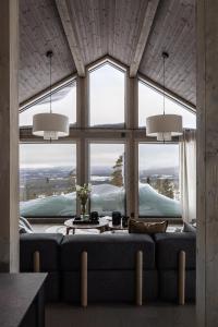 sala de estar con sofá y ventanas grandes en Luxurious Mountain Lodge en Ljørdal