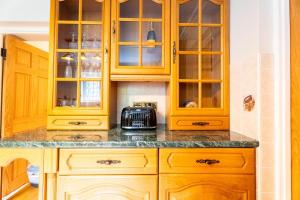 a kitchen with wooden cabinets and a counter top at Luxurious Country Retreat in Winford in Bristol