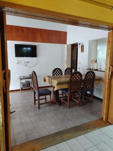 jadalnia ze stołem, krzesłami i telewizorem w obiekcie Ananda w mieście Ushuaia