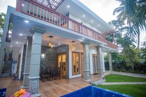 a large house with a balcony and a pool at Ran Villa in Ahangama