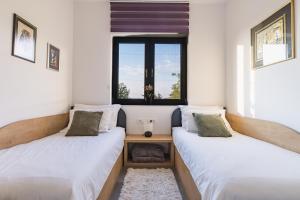 two beds in a room with a window at Villa Boiky - private pool and amazing sea view, Istria in Materada +83 photos