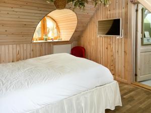 a bedroom with a white bed in a wooden wall at Hotel Strandgaarden in Vesterø Havn