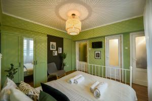Un dormitorio verde con una cama con toallas. en Chic Accommodation with Breathtaking Views over Calea Victoriei - Your Central Heaven, en Bucarest 2 fotos más