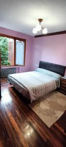 1 dormitorio con 1 cama grande y paredes moradas en Chalet céntrico/costero en Gijón en Gijón