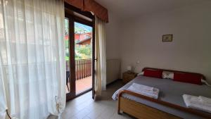 a bedroom with a bed and a large window at Albergo Meublé Aurora in Edolo