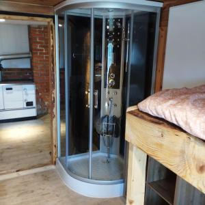 a glass shower in a room next to a bed at Almhütte in Waldenstein