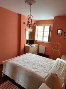 a bedroom with orange walls and a large bed at Apartamento Las Martas in Comillas