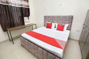 um quarto com uma cama com almofadas vermelhas em OYO Hotel Golden Crown em Sirhind