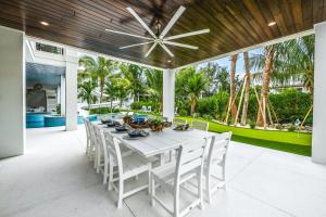 een witte eettafel met witte stoelen en een plafondventilator bij Salty Oak in Siesta Key