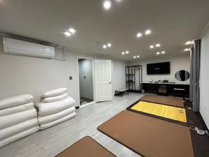 a living room with white furniture and a flat screen tv at Hotel Bom in Mokpo