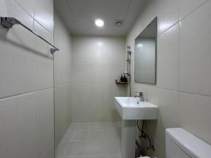 a white bathroom with a sink and a mirror at Hotel Bom in Mokpo