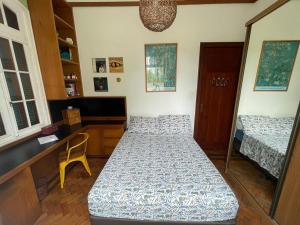 1 dormitorio con 2 camas, escritorio y silla en Casa Vermelha, en Río de Janeiro