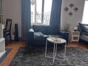 uma sala de estar com um sofá azul e uma mesa em Cosy Studio em Bruxelas
