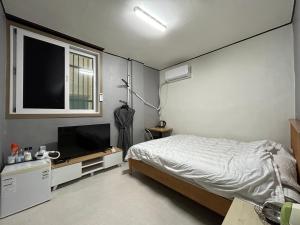 a bedroom with a bed and a flat screen tv at 369 Motel in Mokpo