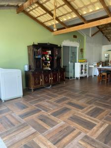 een grote woonkamer met een houten vloer en een tafel bij Casa in Piçarras