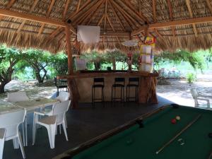 a bar with a pool table and a bar with stools at Mondala Hostal Carrizalillo in Puerto Escondido