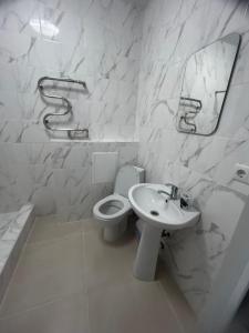 ein weißes Bad mit einem Waschbecken und einem WC in der Unterkunft Готель-ГАЙСИН-Ресторан in Haysyn