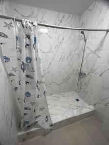 - un rideau de douche avec du poisson dans la salle de bains dans l'établissement Готель-ГАЙСИН-Ресторан, à Haysyn