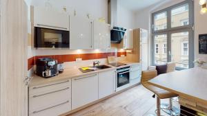 a kitchen with white cabinets and a table with chairs at CozyHome Apartment am Hasselbachplatz in Magdeburg