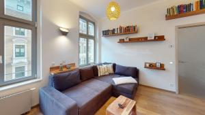 ein Wohnzimmer mit einem braunen Sofa und einem Fenster in der Unterkunft CozyHome Apartment am Hasselbachplatz in Magdeburg