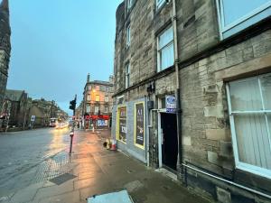 an empty city street with a brick building at Central Edinburgh, Quirky & Modern 1 bed apartment in Edinburgh