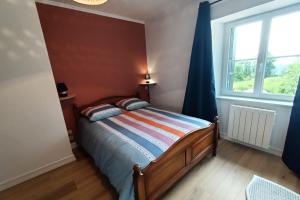 a bedroom with a bed and a large window at GITE 6 personnes à Pailherols in Saint-Clément