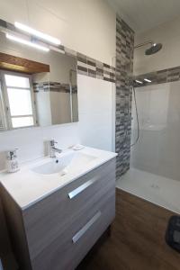 a white bathroom with a sink and a shower at GITE 6 personnes à Pailherols in Saint-Clément