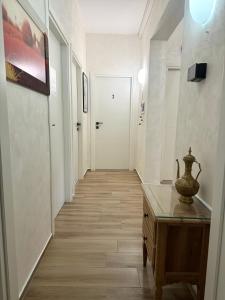 um corredor com uma mesa e uma porta branca em Serenity B&B em Brescia