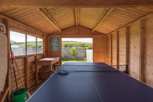 una mesa de ping pong en el interior de una casa de madera en Wooda Farm Holidays, en Bude