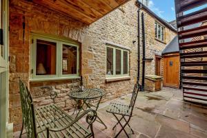 a patio with two chairs and a table at The Old Workshop in Stow on the Wold