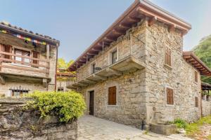 a large stone building with a wooden roof at Ca Luigia in Montorfano in Mergozzo