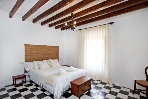 a bedroom with a white bed and a checkered floor at Villa Son Vives Townhouse by Slow Villas in Banyalbufar