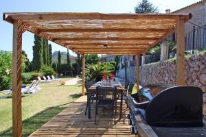 a wooden pergola with a table and chairs under it at Villa Son Vives Townhouse by Slow Villas in Banyalbufar +53 photos