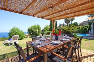 a wooden table and chairs under a wooden pergola at Villa Son Vives Townhouse by Slow Villas in Banyalbufar +52 photos