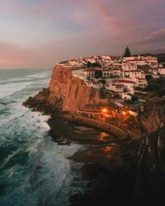 un pueblo en un acantilado cerca del océano por la noche en Azenhas do Mar Roadside House en Colares