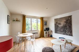 una sala de estar con 2 mesas y sillas y una ventana en Le Bretagne- 2 chambres-Parking- Place de Bretagne, en Rennes
