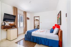 um quarto com uma cama e uma televisão de ecrã plano em Amona Hotel em Hue