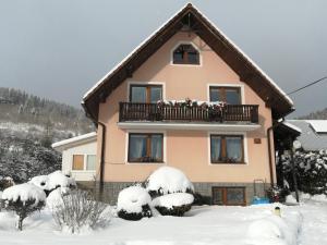 a house with a balcony in the snow at Domček u Vojta in Habovka