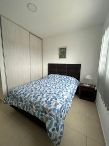 a bedroom with a bed with a blue and white comforter at Edificio Misionero Klein in Resistencia