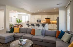 a living room with a couch and a kitchen at Sueno Terra Lago Luxury Pool House in Indio