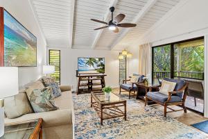 a living room with a couch and chairs and a ceiling fan at Ekolu 1602 in Wailea