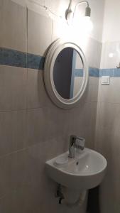 a bathroom with a sink and a mirror at Κεντρικό στούντιο στην Καρδίτσα. in Karditsa