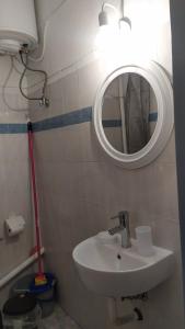 a bathroom with a sink and a mirror on the wall at Κεντρικό στούντιο στην Καρδίτσα. in Karditsa