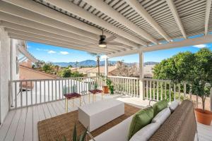 a patio with a couch and chairs on a balcony at The Modern Indio Large Family Home With Pool And Spa in Indio