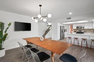 a dining room and kitchen with a wooden table and chairs at The Modern Indio Large Family Home With Pool And Spa in Indio
