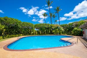 a swimming pool with palm trees in the background at Ekolu 1602 in Wailea