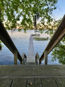 een dok op een meer met een boot in het water bij Smooth Sailing on Lake Waccamaw in Lake Waccamaw